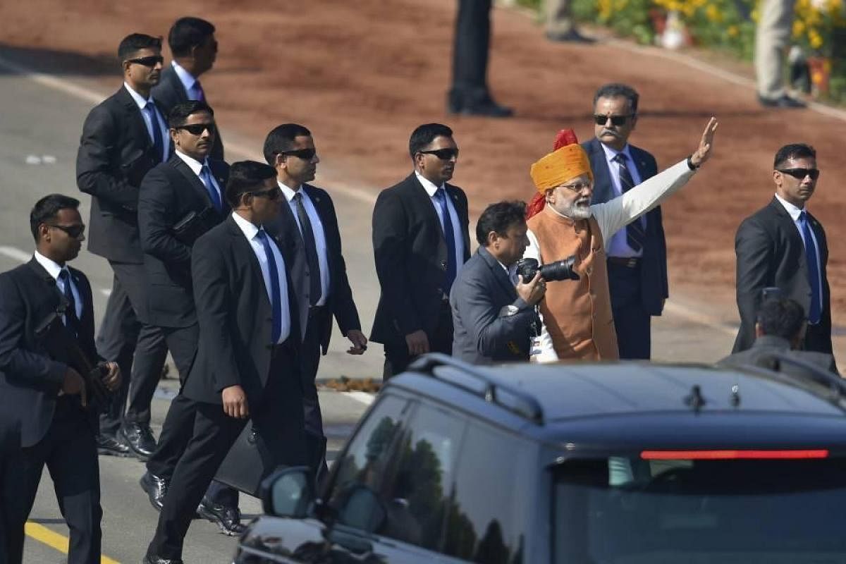 Who are the security men in black with briefcases around the PM on