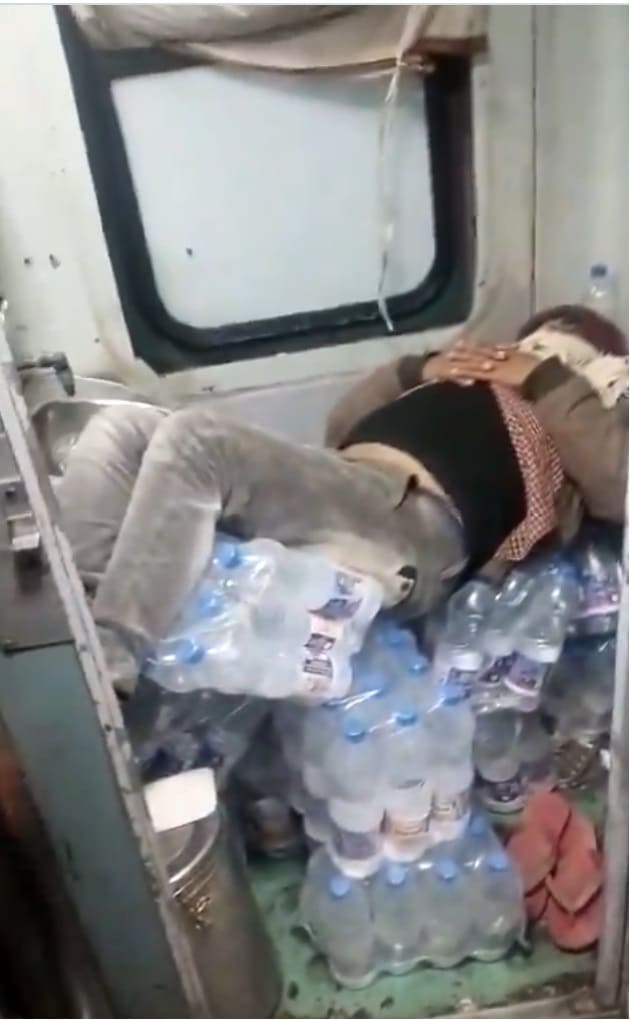 Man inside train toilet on water bottles