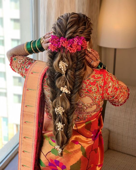 Loose voluminous braid styled with flowers
