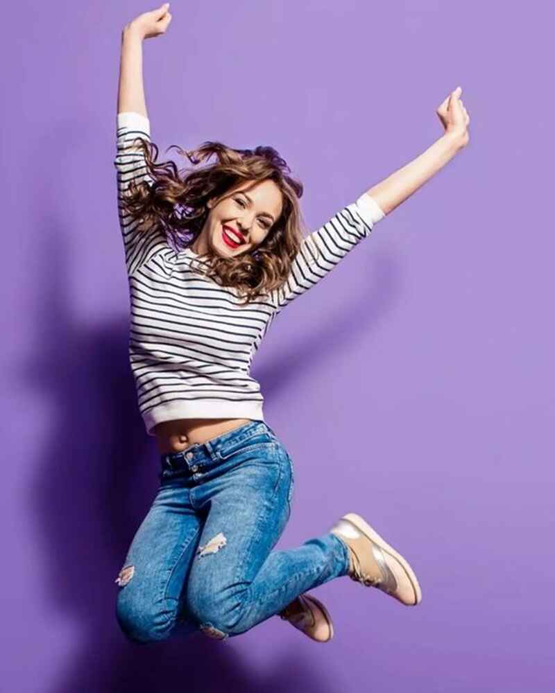 Playful-jump-photo-poses-for-girl-in-jeans-top-at-home