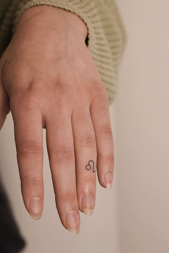 zodiac symbol finger tattoo