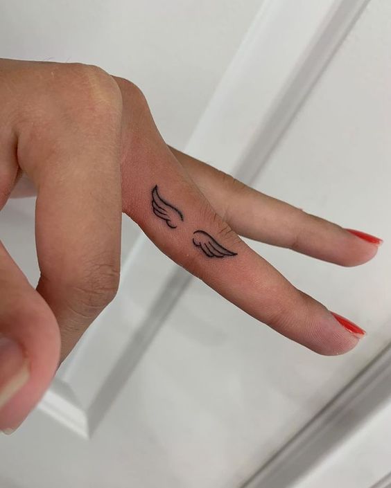 angel wings finger tattoo