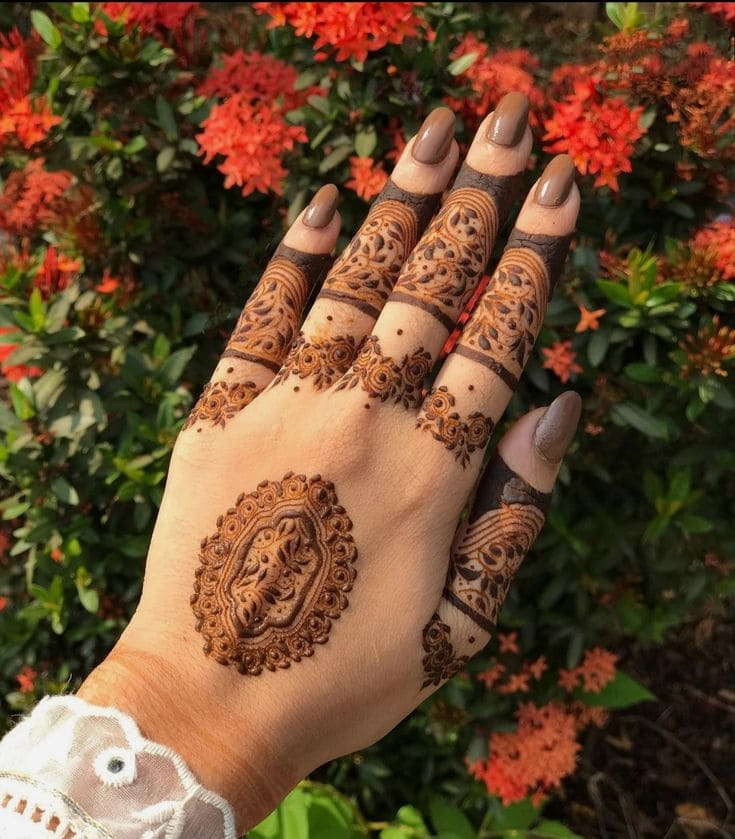 Intricate finger mehndi with central motif